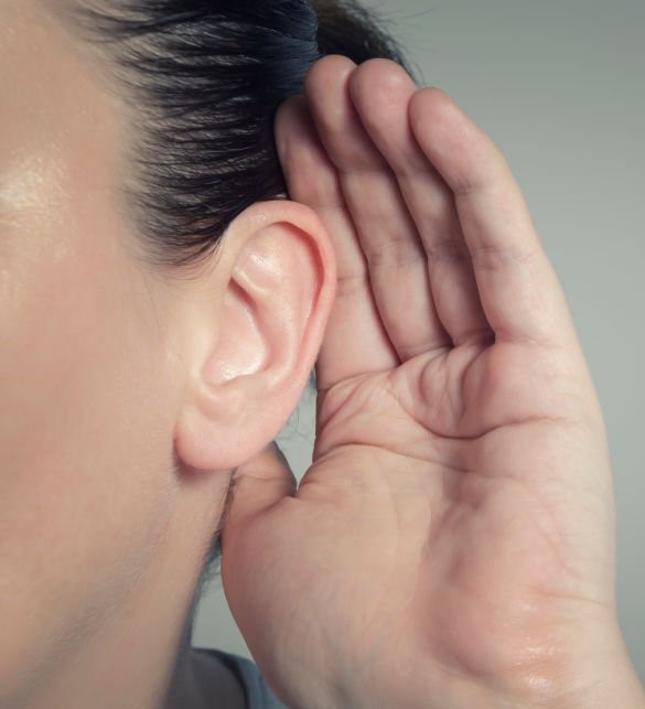 Woman with hand on ear listening for quiet sound or paying attention
